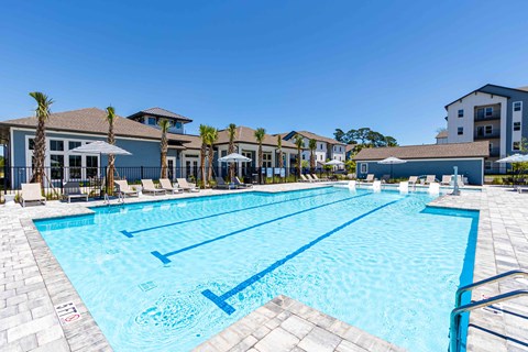 A large swimming pool with lane markers and a building in the background.