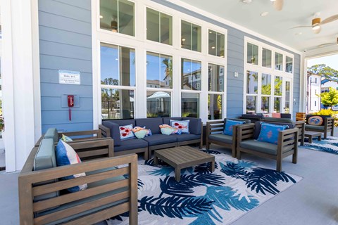 A blue building with a sign on it and a blue rug with palm tree designs in front of it.