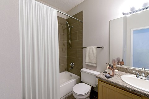 A bathroom with a white toilet, a white sink, and a white shower curtain.