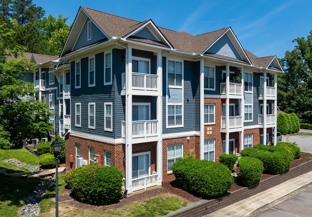 an apartment building with brick and blue exterior and balconies