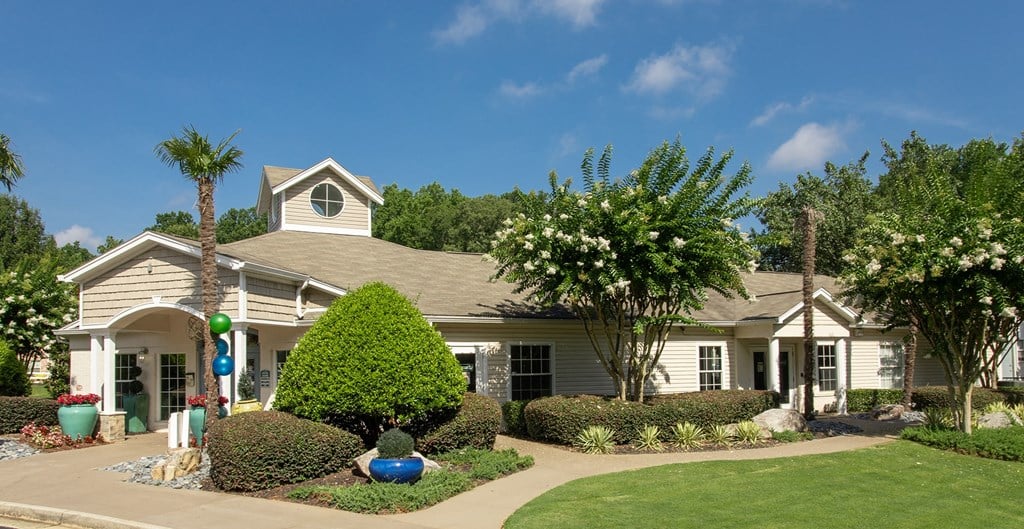 a house with a lawn and trees in front of it
