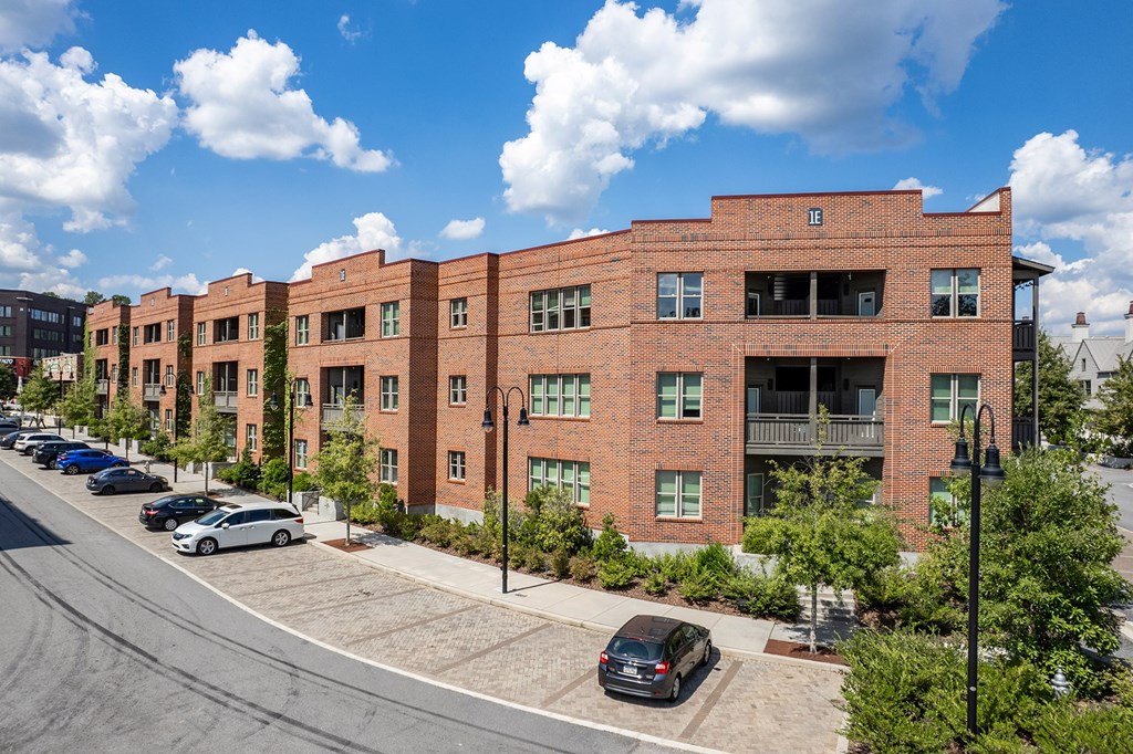 A street view of a row of red brick apartment buildings.