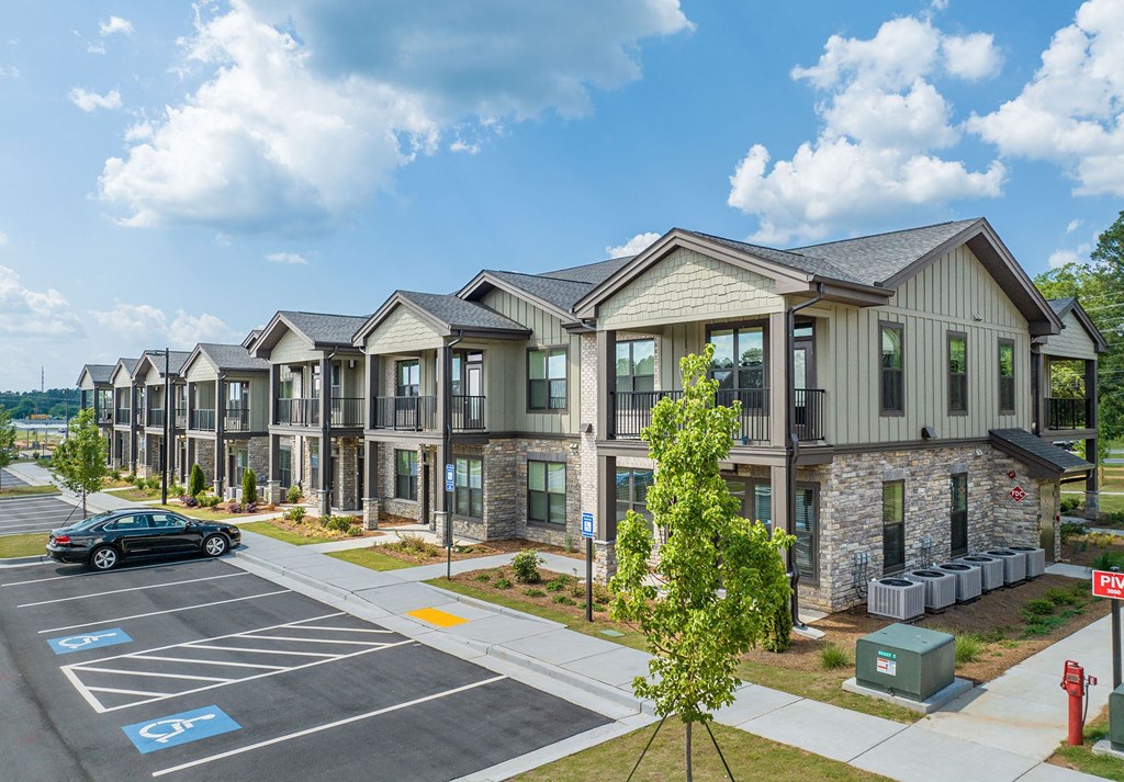 a row of townhouses with a car parked in a parking lot