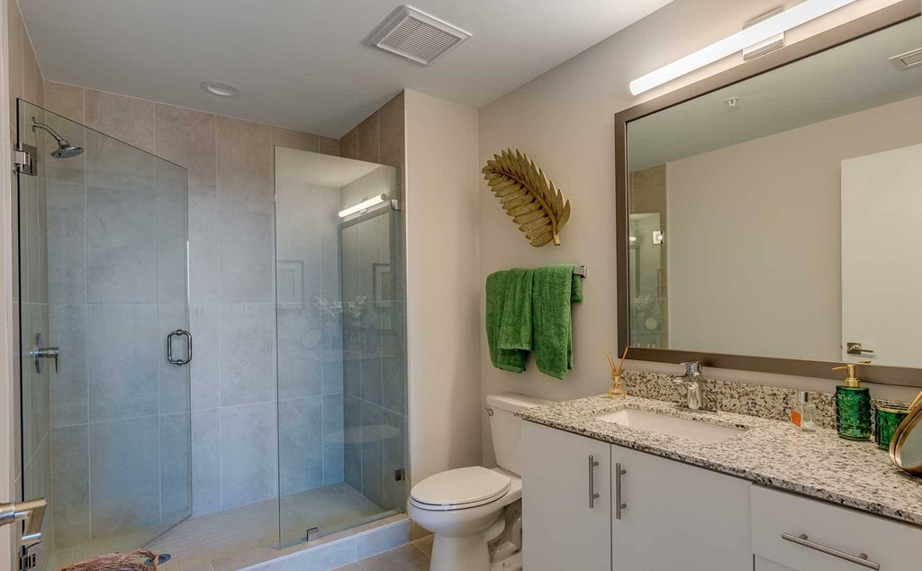A bathroom with a toilet, sink, and shower.