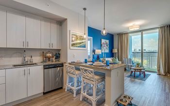 A kitchen with white cabinets and a blue accent wall.