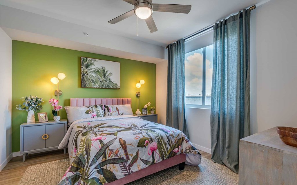 A bedroom with a bed, nightstand, and a painting on the wall.