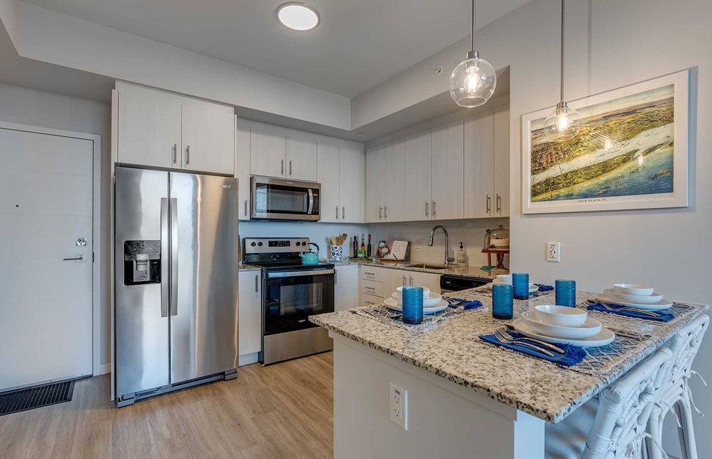 A kitchen with a granite countertop and stainless steel appliances.