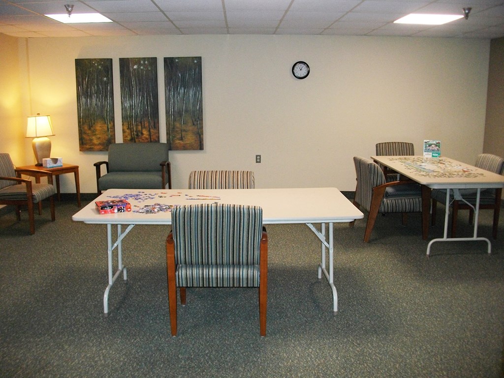 a room with tables and chairs and a clock on the wall