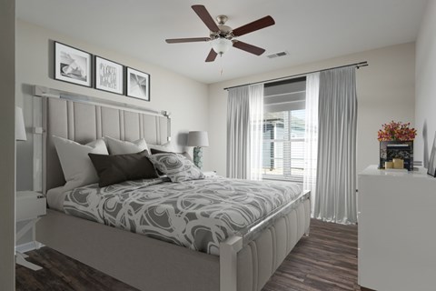 A bedroom with a large bed and a ceiling fan.