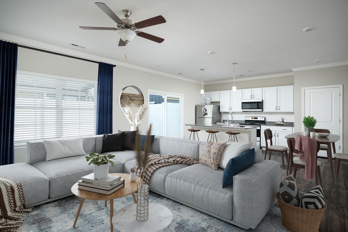 a living room and kitchen with a couch and a ceiling fan