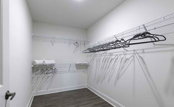 A white closet with a white door and a white towel on a shelf.