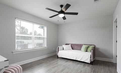 A living room with a white couch and a ceiling fan.