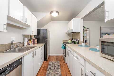 A kitchen with white cabinets and a black refrigerator.