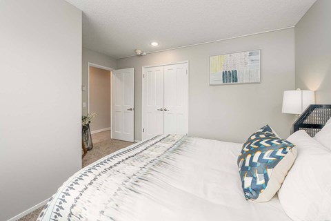 A bedroom with a large bed and a painting on the wall.