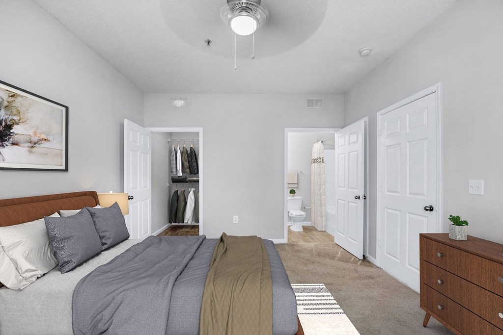 A bedroom with a bed, dresser, and a painting on the wall.