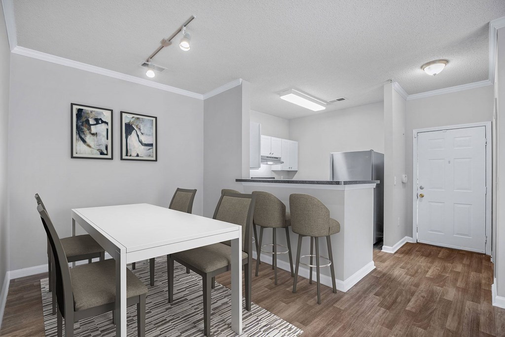 A kitchen with a dining table and chairs.