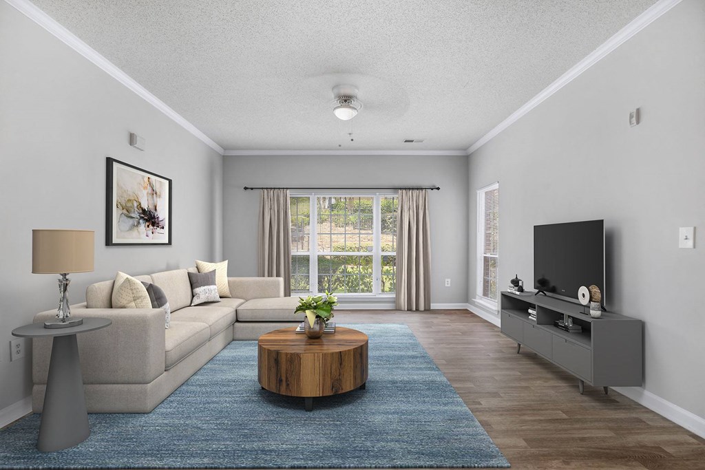 A living room with a grey couch, a wooden coffee table, and a flat screen TV.