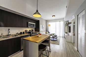A modern kitchen with dark wood cabinets and a wooden island.