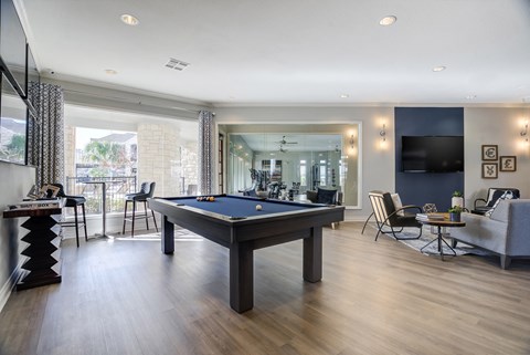 a pool table in the center of a living room with a tv