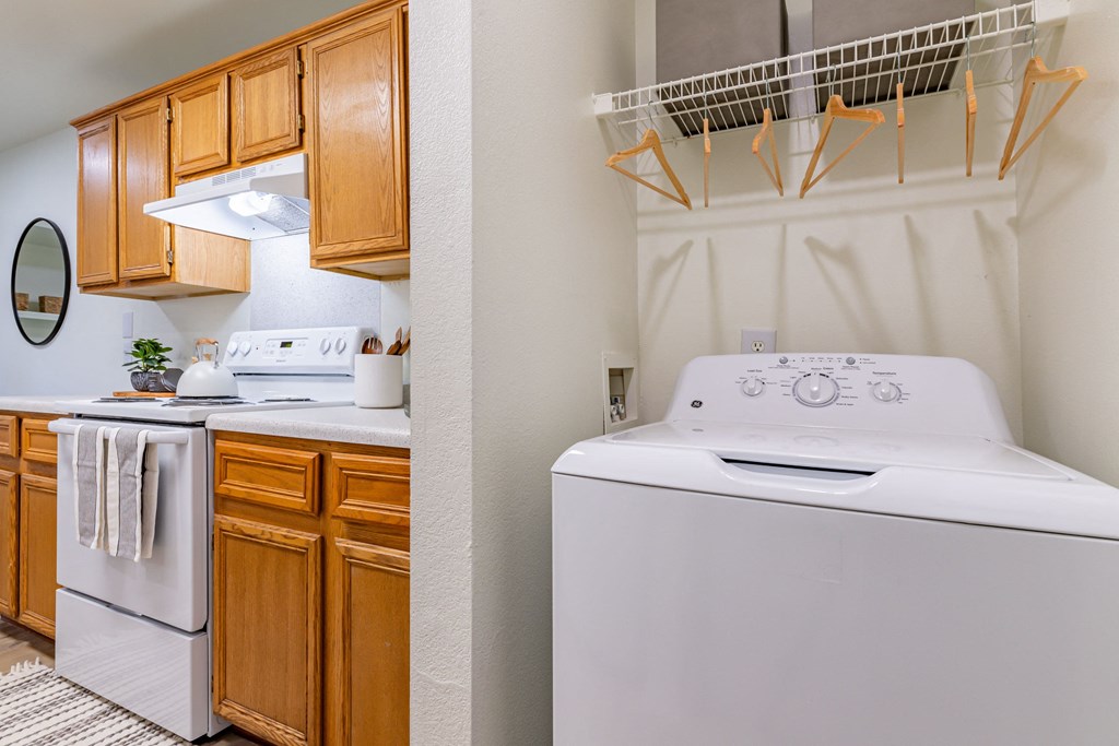 a kitchen with a washer and dryer and a laundry room with wooden cabinets