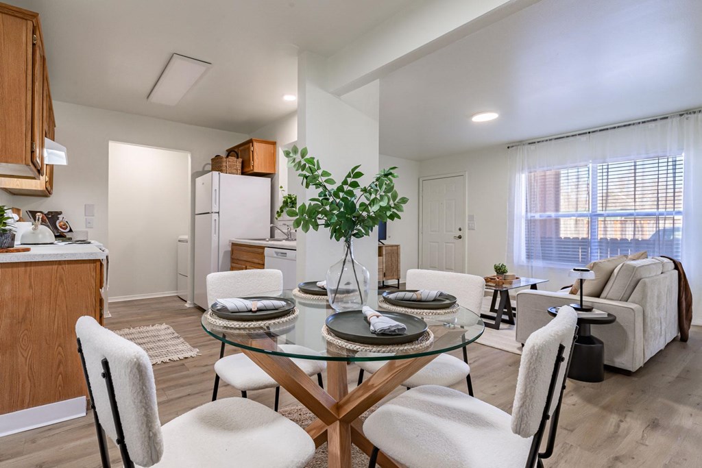 a living room with a table and chairs and a kitchen