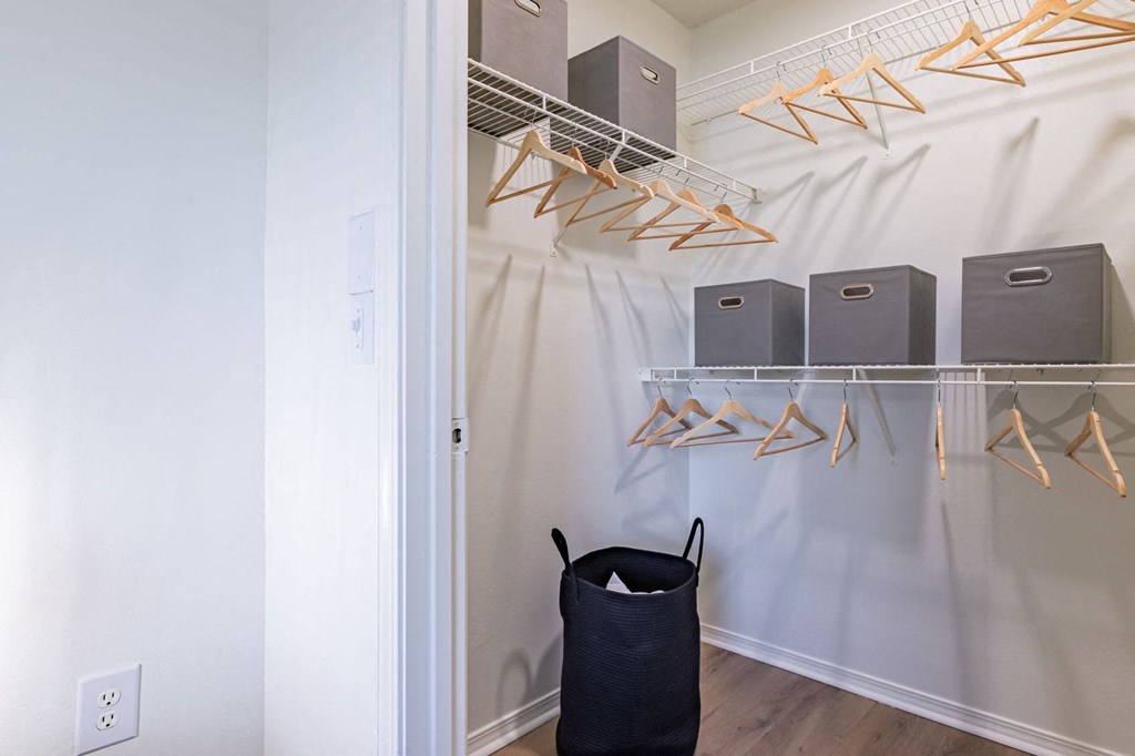 a walk in closet with a basket and shelves