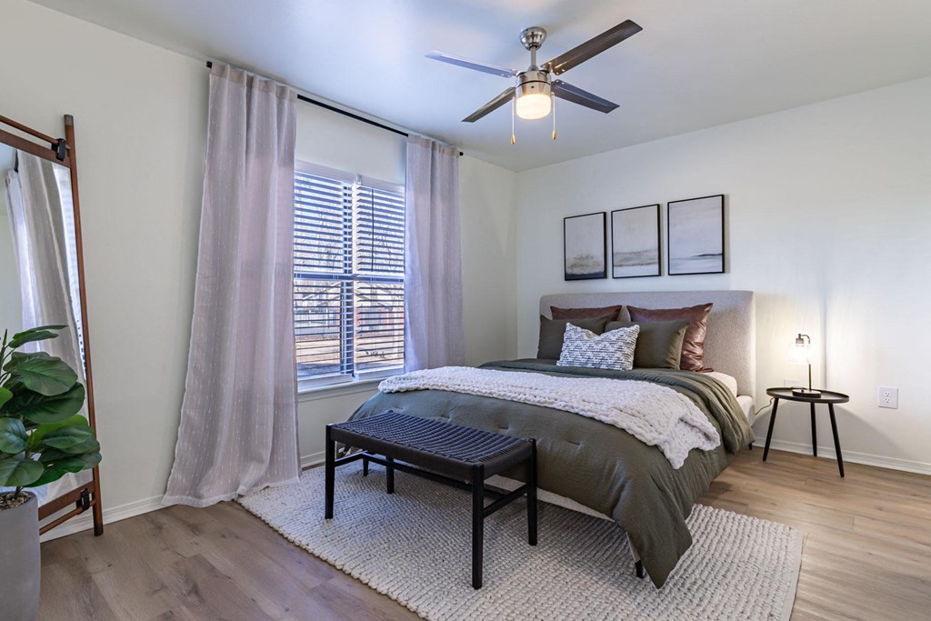 a bedroom with a bed and a ceiling fan