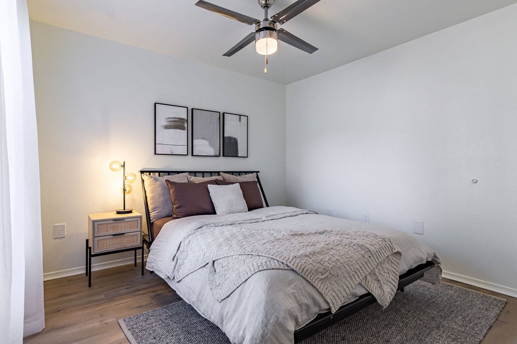 a bedroom with a bed and a ceiling fan