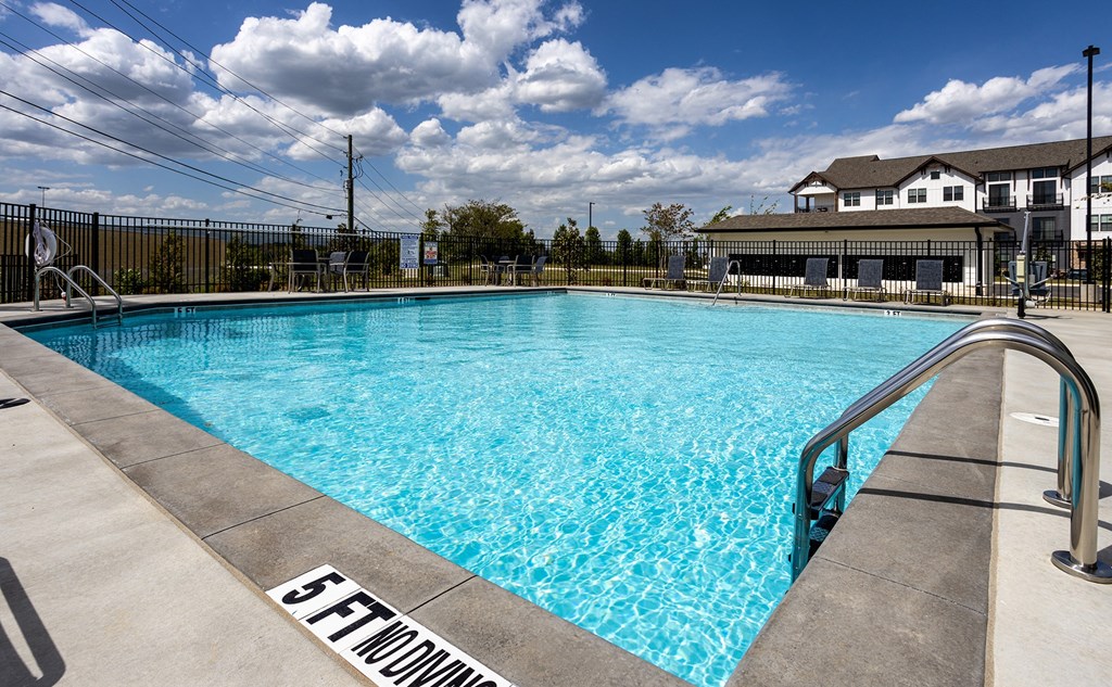 a swimming pool with a house in the background