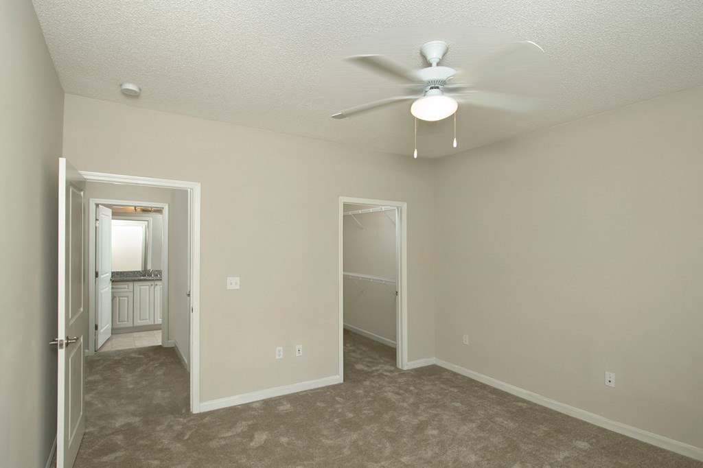 an empty living room with a ceiling fan