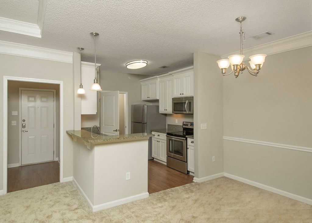 an open kitchen and living room with a large counter top