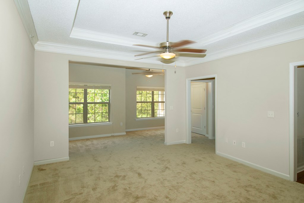 an empty living room with a ceiling fan