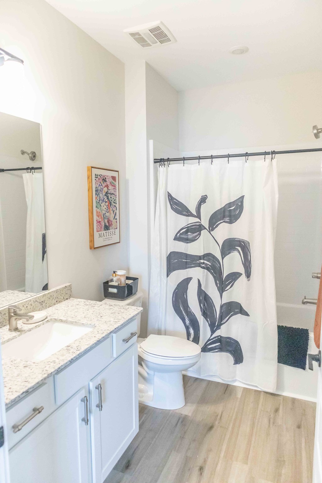 a bathroom with a shower curtain with a plant on it