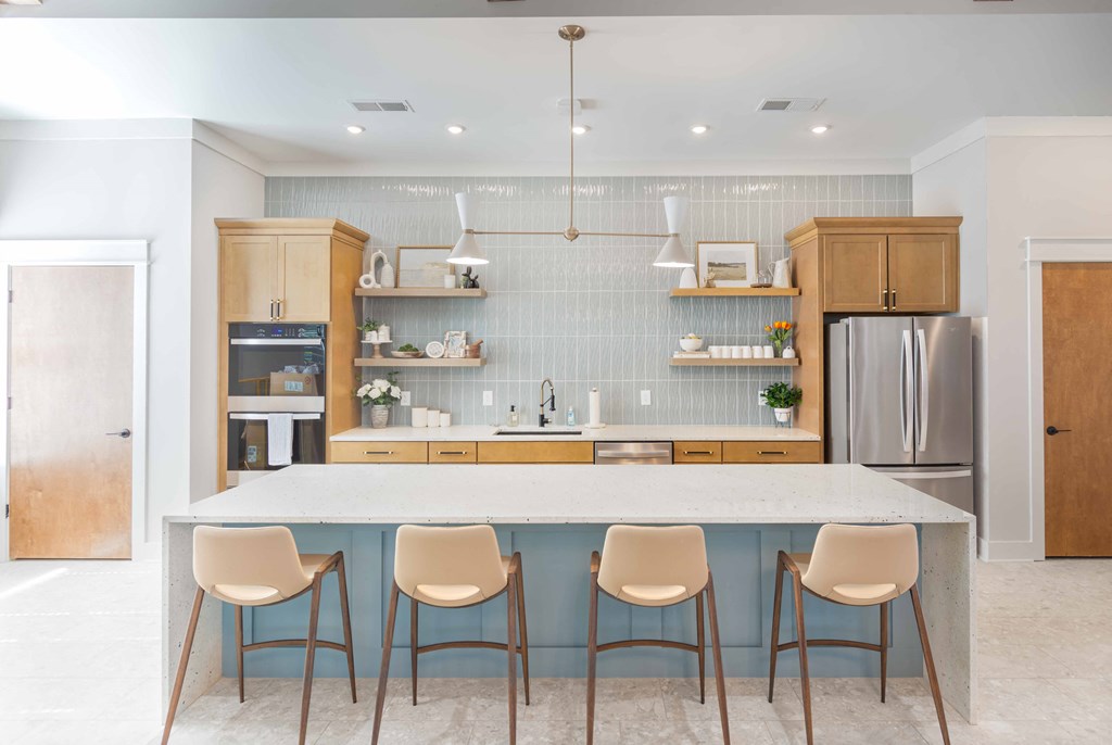 a kitchen with a marble counter top and four chairs