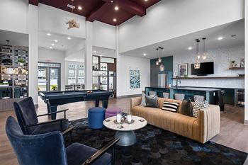 A modern living room with a pool table and a couch.