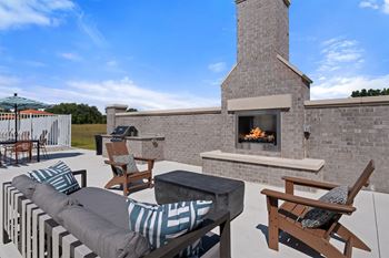 A patio with a fireplace and seating area.