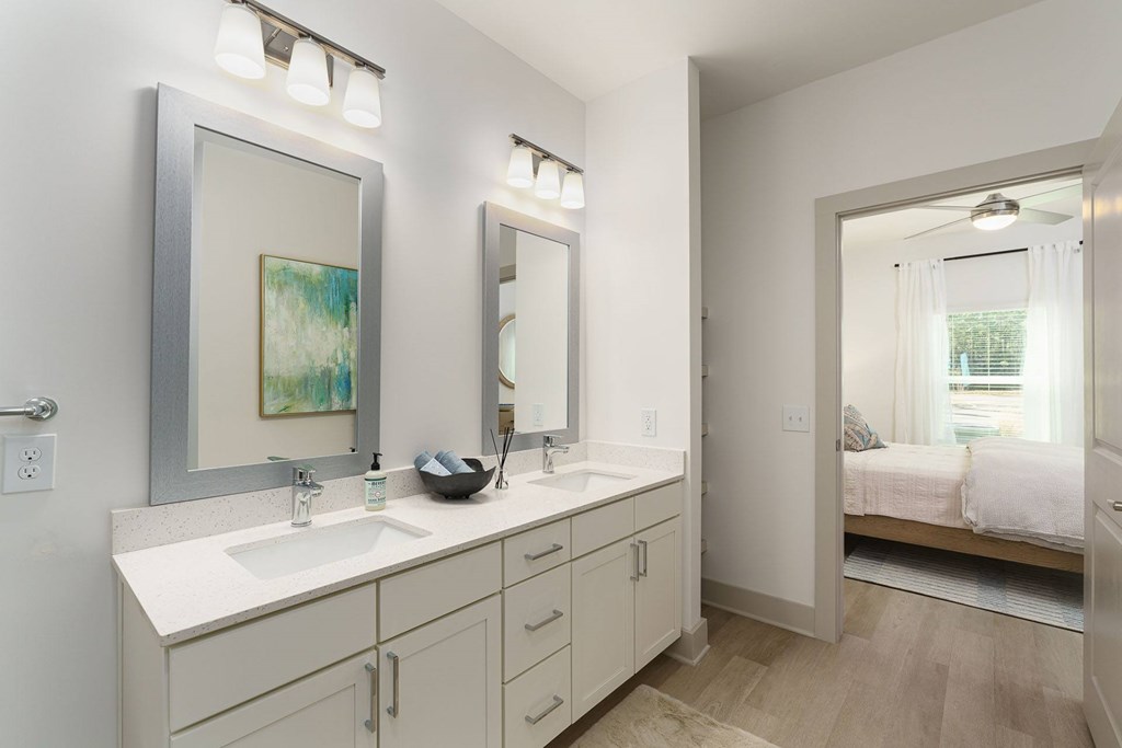 A bathroom with a white countertop and a large mirror above it.