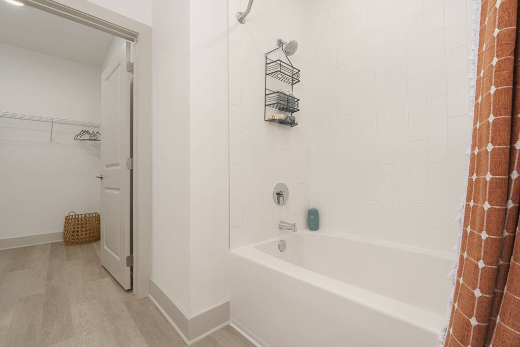 A white bathroom with a tub and a shower.