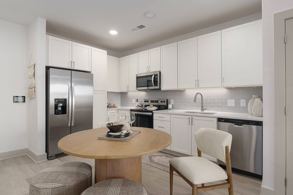 A modern kitchen with a round table and a refrigerator.
