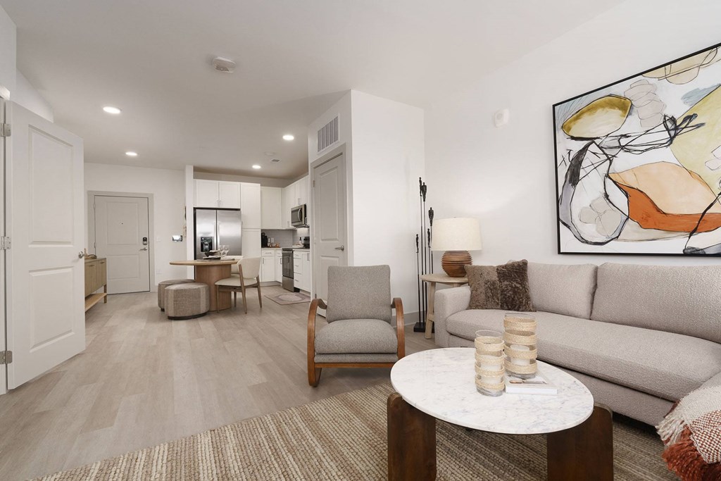 A living room with a couch, chair, and a painting on the wall.