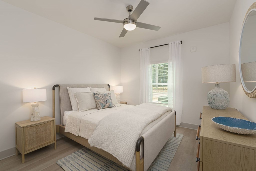 A bedroom with a bed, nightstand, and a ceiling fan.