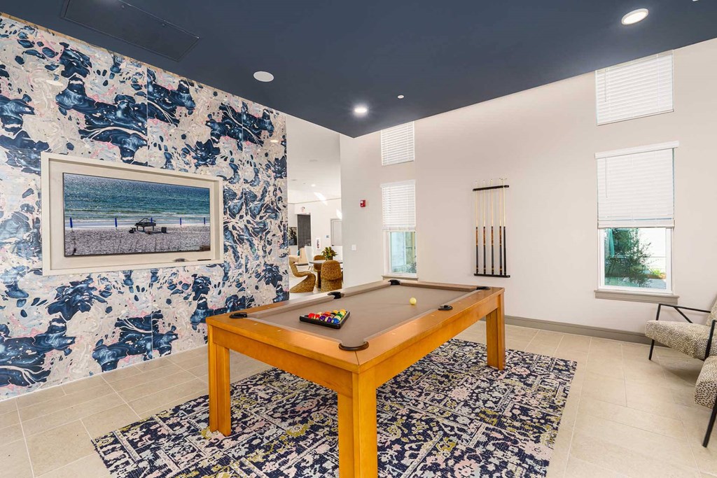 A pool table in a room with a blue and white floral wallpaper.