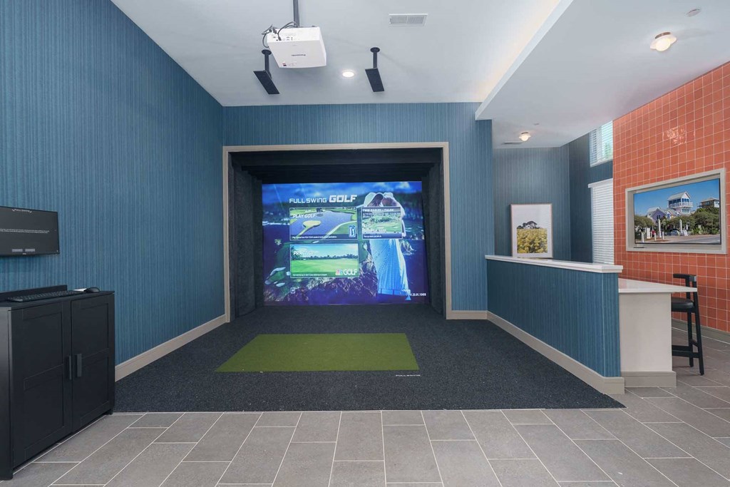 A room with a large screen and a green rug in front of it.