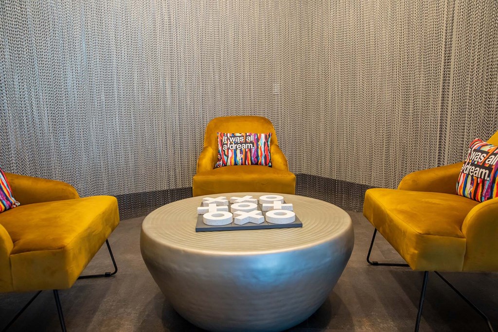 clubhouse room with three chairs and a table with a sculpture on top of it