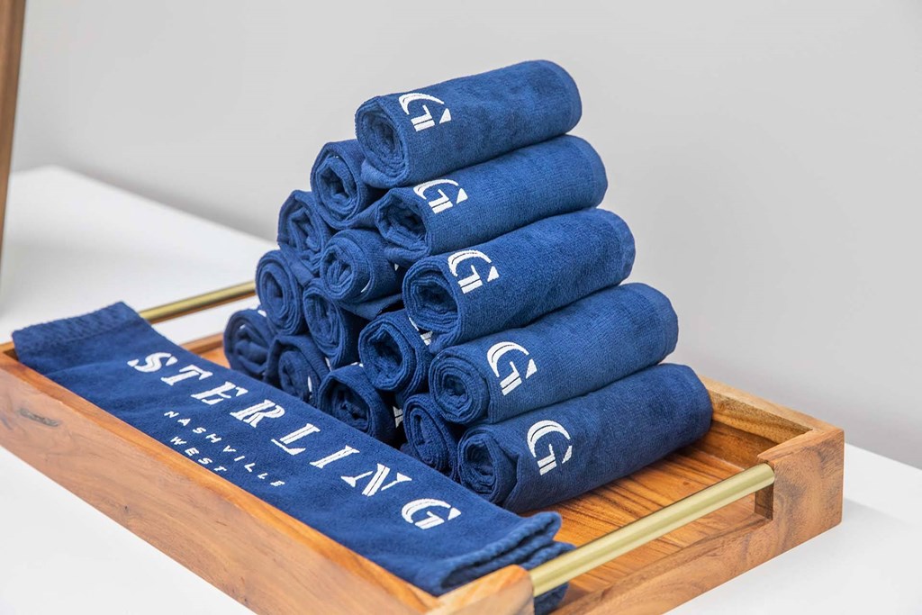 a tray with a stack of navy blue towels with white lettering