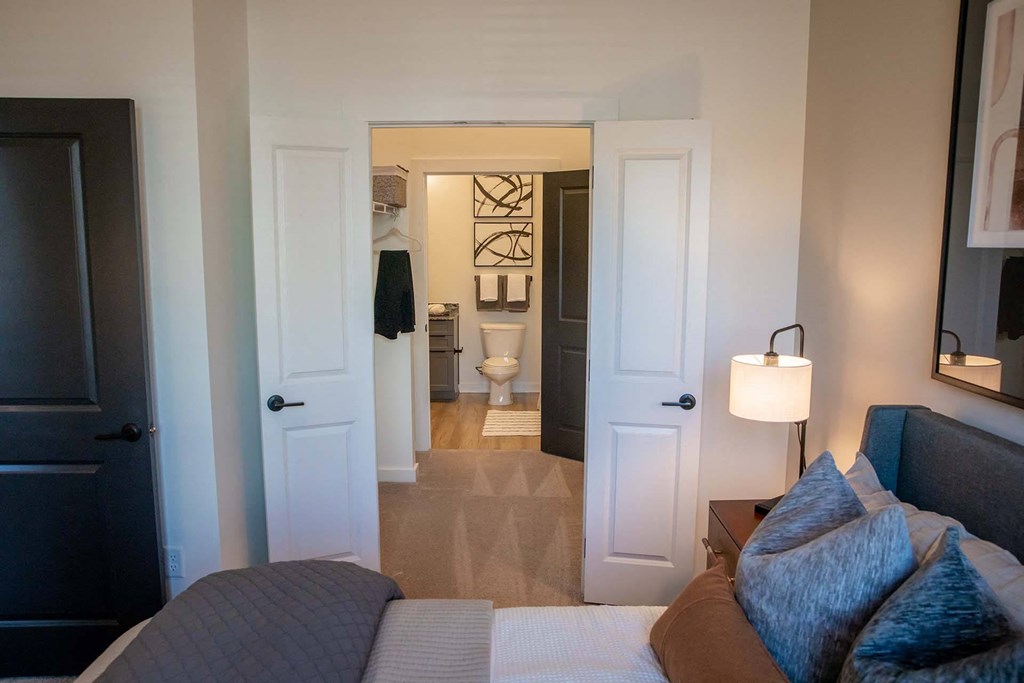 a bedroom and a bathroom in the background