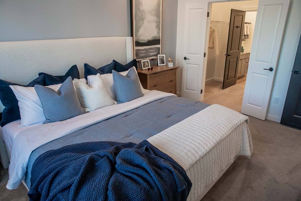 a bedroom with a large bed with blue and white bedding