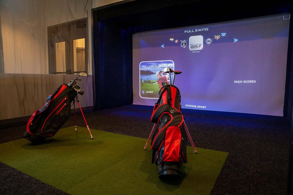 a golf bag and a golf club on display in front of a screen