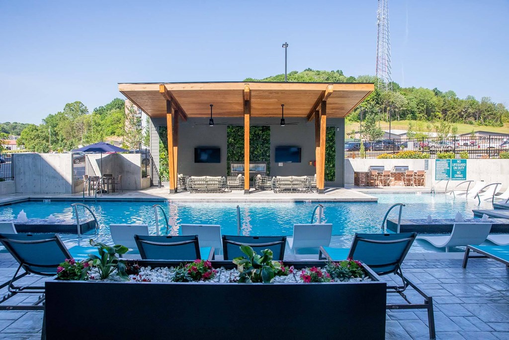 a swimming pool with a poolside bar and lounge chairs