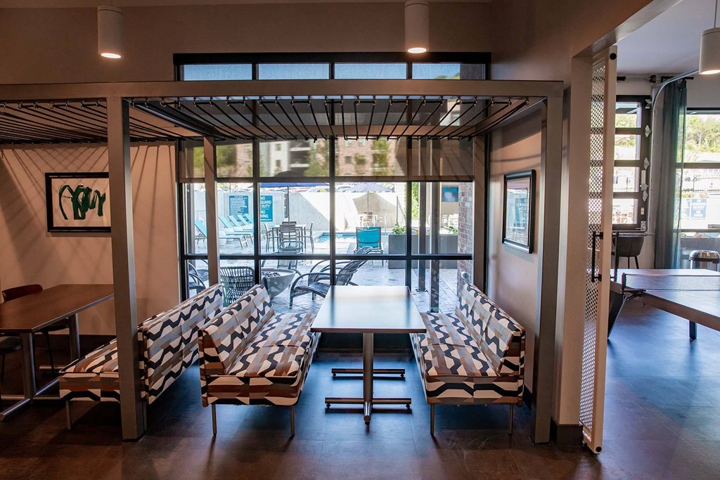 a room with a table and chairs and a large window